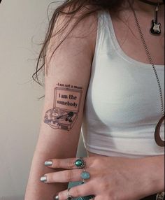 a woman with a tattoo on her arm that reads, i am the somebody and is holding a cell phone