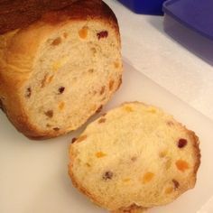 two pieces of bread sitting on top of a cutting board next to a blue container