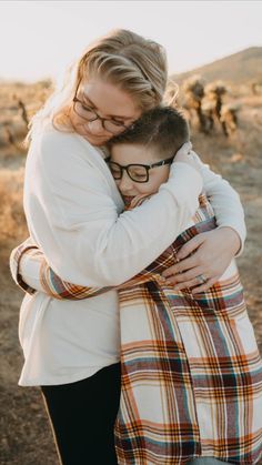 a woman hugging her son in the middle of a field