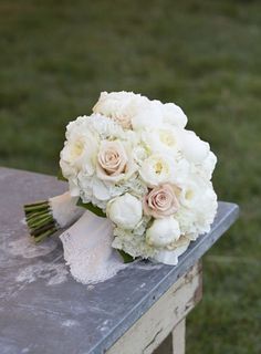 a bouquet of white flowers sitting on top of a bench