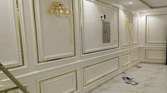 an empty room with white walls and gold trimmings on the doors, flooring and chandeliers