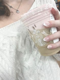 a woman holding a starbucks cup in her right hand