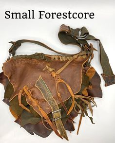 This Forestcore bag is made of brown conditioned leather as the base with green and olive brown accent pieces. The brown leather has many variations of color adding interest and depth to the piece. The main body is leaf shaped with a panel connecting the front to the back. The panel allows for a spacious interior. A leafy lid folds over the body and is secured with a strap and buckle. A leafy green pocket is stitched to the front. I have woven in strips of leather. I used the rough raw edges of Artisan Handmade Brown Satchel, Artisan Brown Satchel For Festival, Rustic Brown Bags With Leather Handles, Brown Bohemian Leather Satchel, Brown Leather Bohemian Satchel, Bohemian Brown Leather Satchel, Hippie Handmade Brown Shoulder Bag, Hippie Brown Handmade Shoulder Bag, Handmade Brown Bags For Festival