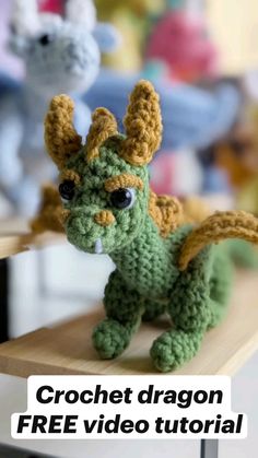 a crocheted dragon sitting on top of a wooden table