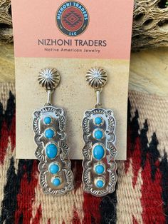 New without tags BRAND : Nizhoni Traders LLC ETHNIC & REGIONAL STYLE : Native American JEWELRY TYPE : Earrings METAL : Sterling Silver TRIBAL AFFILIATION : Navajo MAIN STONE : Turquoise Lovely Navajo Turquoise and Sterling Silver dangle earrings. Measure 2 7/8 inches long and 3/4 of an inch wide. Great pair of earrings! Stamped Sterling and signed by the artist. Thank you for checking out my store. Please contact me with any questions. Exported By exportyourstore.com Southwestern Style Blue Pierced Earrings, Southwestern Style Blue Earrings For Pierced Ears, Southwestern Blue Earrings For Pierced Ears, Southwestern Blue Earrings For Gift, Blue Southwestern Style Earrings For Gift, Artisan Blue Drop Earrings, Southwestern Style Blue Drop Earrings, Southwestern Blue Drop Earrings, Navajo Turquoise