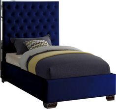 a bed with blue upholstered headboard and pillows