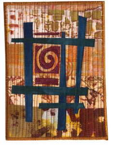 a quilted wall hanging with an abstract design