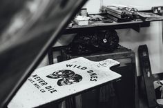 a black and white photo of a wild ones sign in a room full of junk