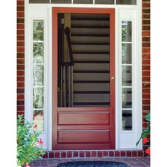 the front door is painted red and has two sidelights on each side, along with an entry mat