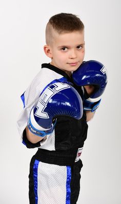 a young boy wearing blue and white boxing gloves