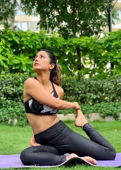 a woman is doing yoga outside in the grass