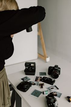 a woman is taking pictures with her camera and other things on the table in front of her