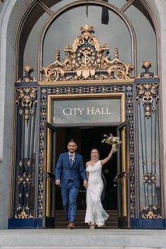 a bride and groom exiting the city hall