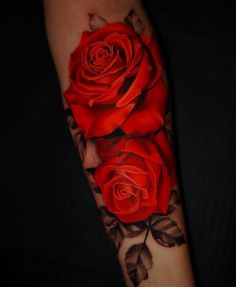 a woman's arm with two red roses on it