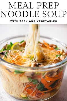 a glass bowl filled with noodles and vegetables