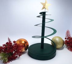 a green christmas tree with gold ornaments around it