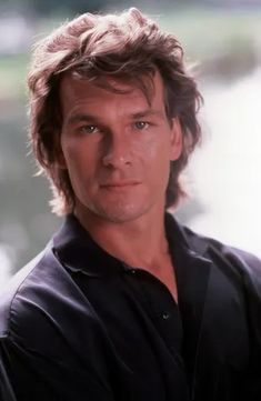 a close up of a person wearing a black shirt and holding something in his hand