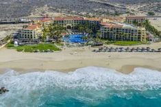 an aerial view of the resort and beach from above, with waves crashing in front