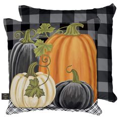 three pumpkins on a black and white checkered pillow