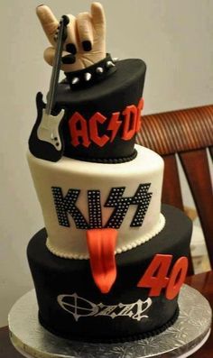 a three tiered cake decorated with guitars and the words ac / dc on it