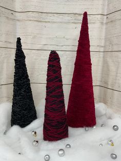 three small christmas trees sitting in the snow