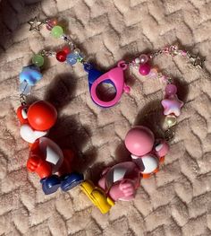 the necklace is made up of different colored beads and plastic toys on a carpeted surface