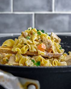 a skillet filled with pasta and chicken