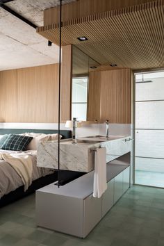 a bedroom with a bed, sink and mirror on the wall next to each other