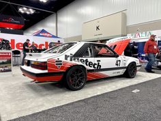 a white and red car on display at an auto show