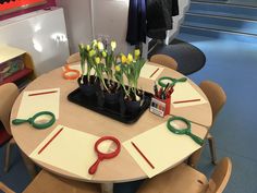 a table with scissors and flowers on it in a children's playroom area