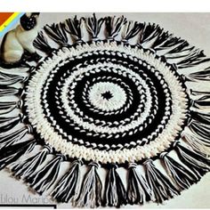 a black and white circular rug with fringes