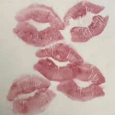 four imprints of lipstick on a white surface