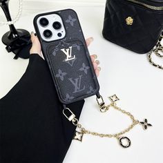 Premium Monogram Canvas: Crafted from high-quality LV monogram canvas, this iPhone case features Louis Vuitton's iconic design, ensuring both luxury and durability. The signature monogram pattern adds a touch of classic elegance to your device. Integrated Back Card Holder: The case includes a convenient back card holder, allowing you to securely store essential cards such as credit cards, IDs, or transit passes. This practical feature helps you streamline your daily carry by keeping your essentials in one place. Detachable Hand Chain: Equipped with a stylish and functional hand chain, this case offers enhanced portability and security. The hand chain allows you to carry your phone effortlessly, reducing the risk of accidental drops while adding a fashionable accessory to your ensemble. Com Luxury Black Travel Phone Accessories, Luxury Black Mobile Phone Bag, Louis Vuitton New, Daily Carry, Buy Louis Vuitton, Luxury Phone Case, Black Iphone Cases, Monogram Pattern, Apple Iphone Case