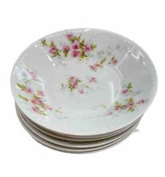 four white plates with pink flowers on them