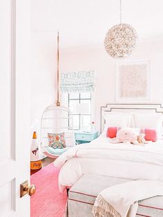 a bedroom with pink carpet, white bedding and an animal cage hanging from the ceiling