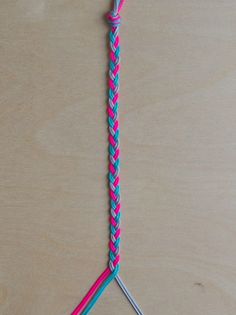 two crochet hooks on a wooden surface, one pink and the other blue