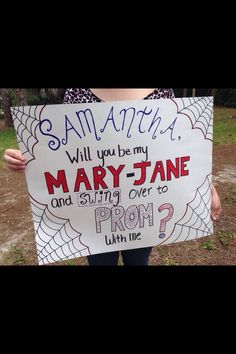 a woman holding up a sign that says mary jane and spider - man from prom