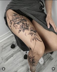 a woman's leg with flowers on it and her legs crossed in the air