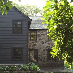 a stone house is surrounded by greenery and trees