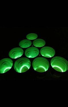 glow in the dark candles are arranged on top of each other, with green lights