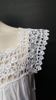 the back of a white dress with crochet on it