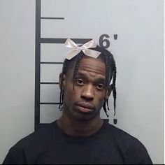 a mug shot of a man with dreadlocks and a t - shirt on