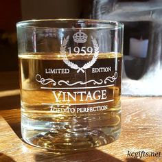 an old fashioned whiskey glass sitting on a table with the label etched into it's side