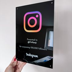 a person holding up a sign with the instagram logo on it