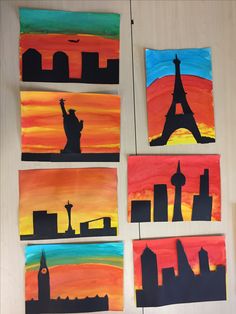 four paintings depicting the silhouettes of different countries and their famous landmarks are displayed on a wall