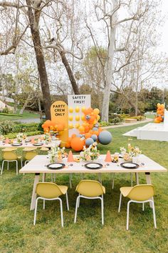 an outdoor party with yellow chairs and balloons