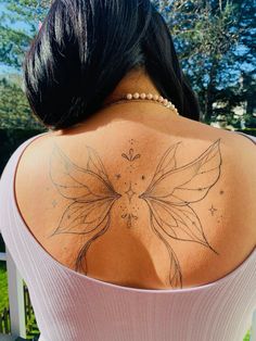 the back of a woman's shoulder with a butterfly tattoo on it