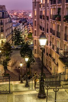 the city is lit up at night with street lights and buildings in the back ground