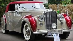 an old fashion car is parked on the street