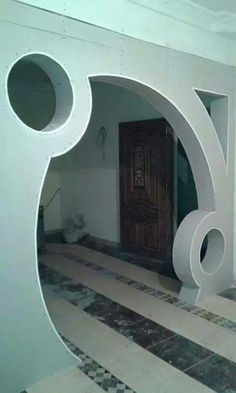 a large white sculpture in the middle of a room with tile flooring and walls